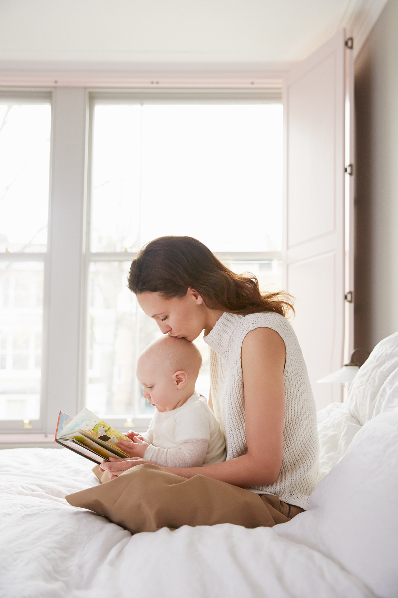 Mummy reading with baby in bed