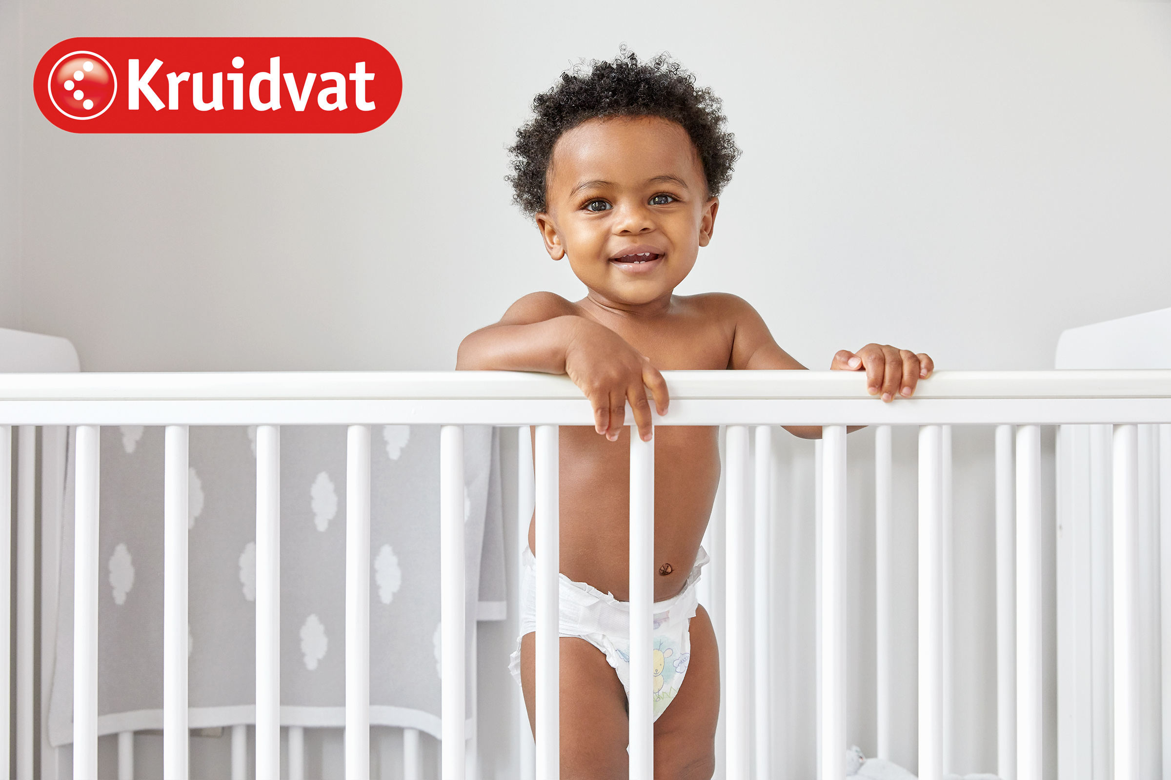 Happy baby standing in crib Emma Tunbridge