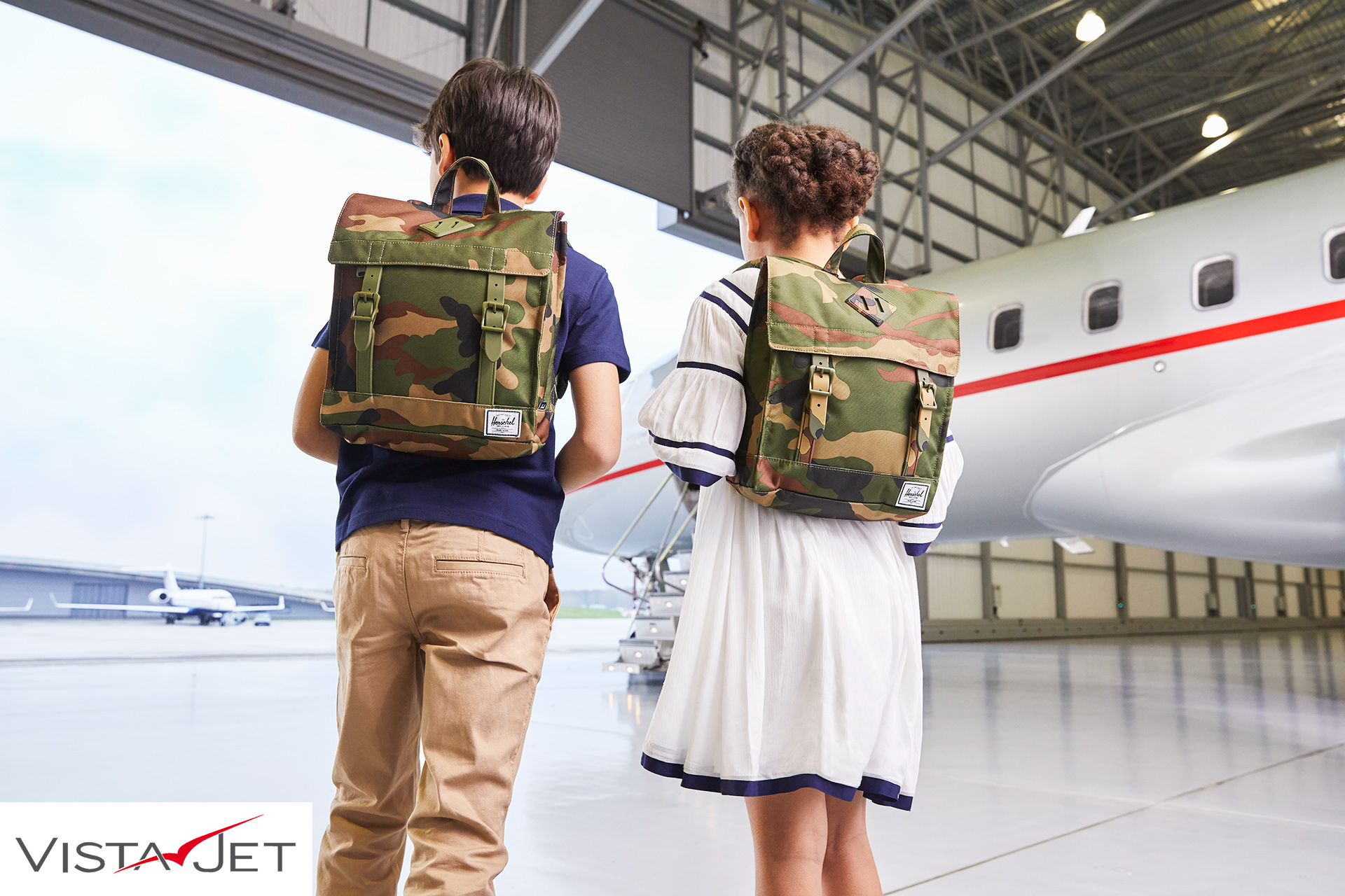 Children boarding a plane with backpacks
